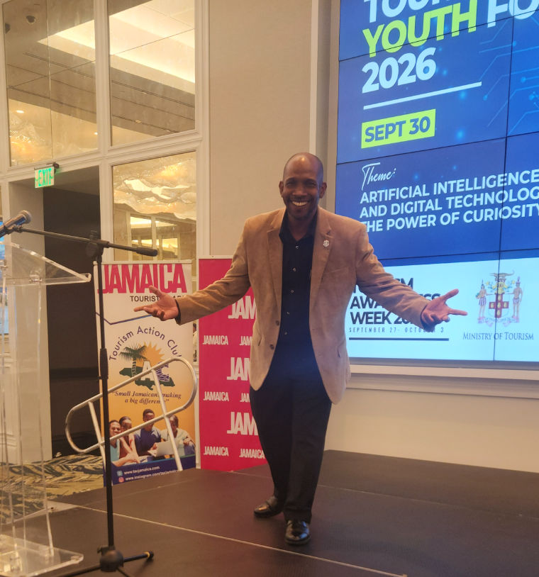 Howard Goode speaking on stage in Jamaica